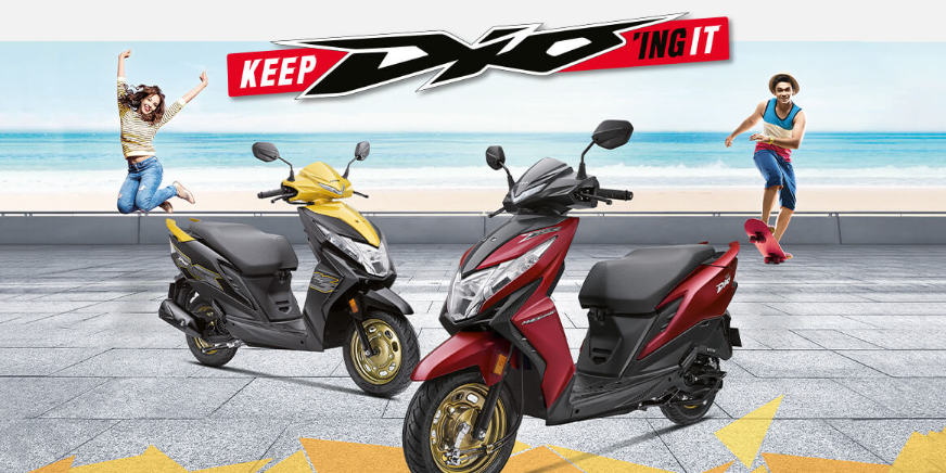 Checkout Red and Yellow Metallic Honda Dio OBD2 at reasonable price exclusively at Rushabh Honda, Nashik. Best Two wheeler Honda Dealers for years.